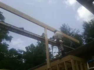 Carpenter setting a ridge beam over a new addition frame — Ice Dam Removal by Roofing Brothers in Gilmanton