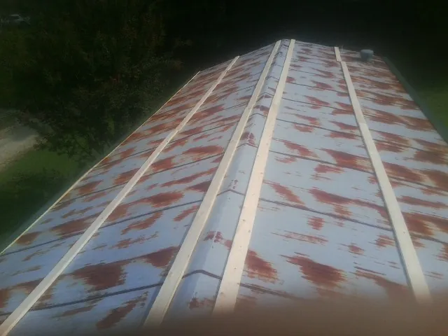 Rusted metal roof panels with new wood purlins before replacement — Storm Damage Roof Repair in Gilmanton by Roofing Brothers